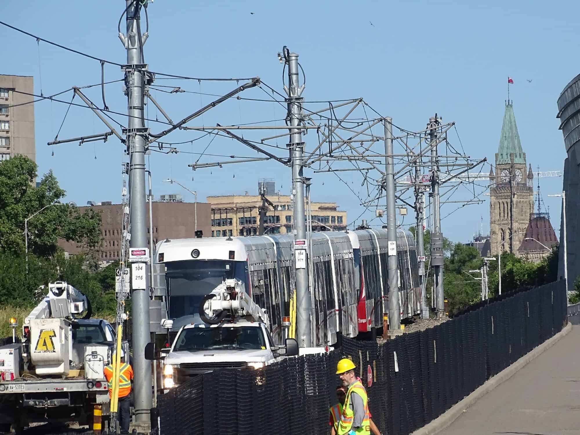 Repairs on the track to a Ottawa LRT vehicle with Parliament in the background. The unreliable and over-priced Ottawa LRT was built by a public-private partnership.