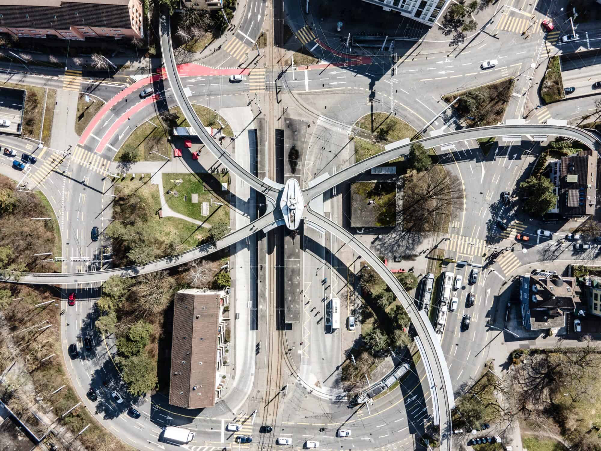 Overhead perspective of an infrastructure hub in a town where car traffic, bike lanes, tram lines and pedestrian walkways intersect.