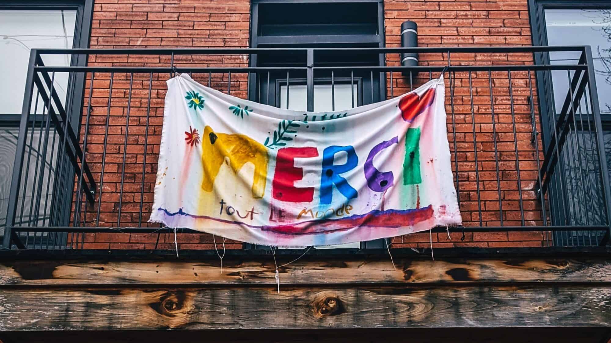 Flag on Montreal home hand painted to say "Merci tout le monde" during early days of the COVID-19 pandemic.