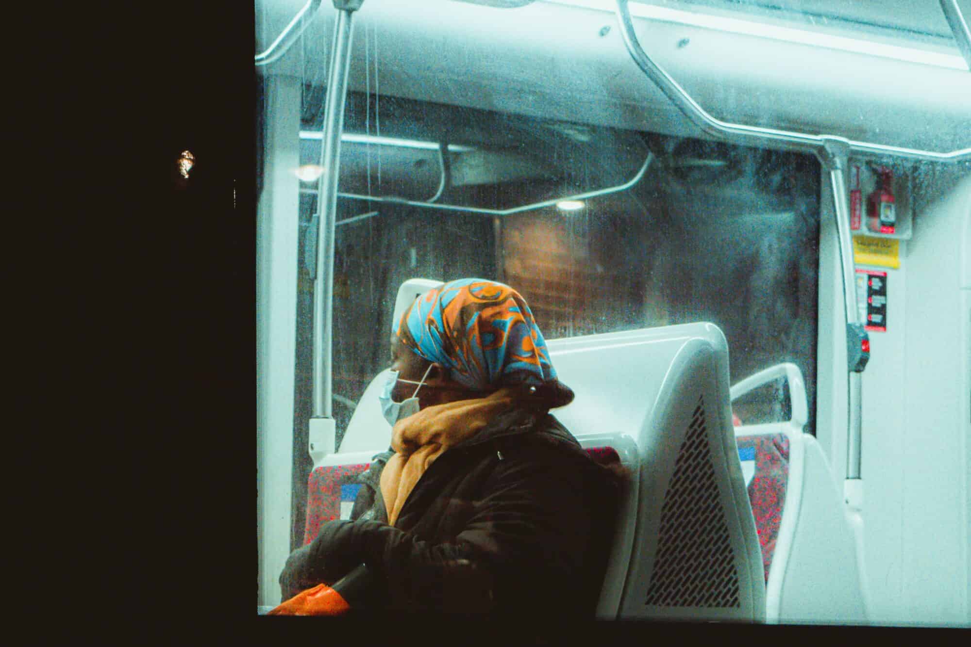 A TTC passenger wearing a surgical mask sits in a TTC streetcar.
