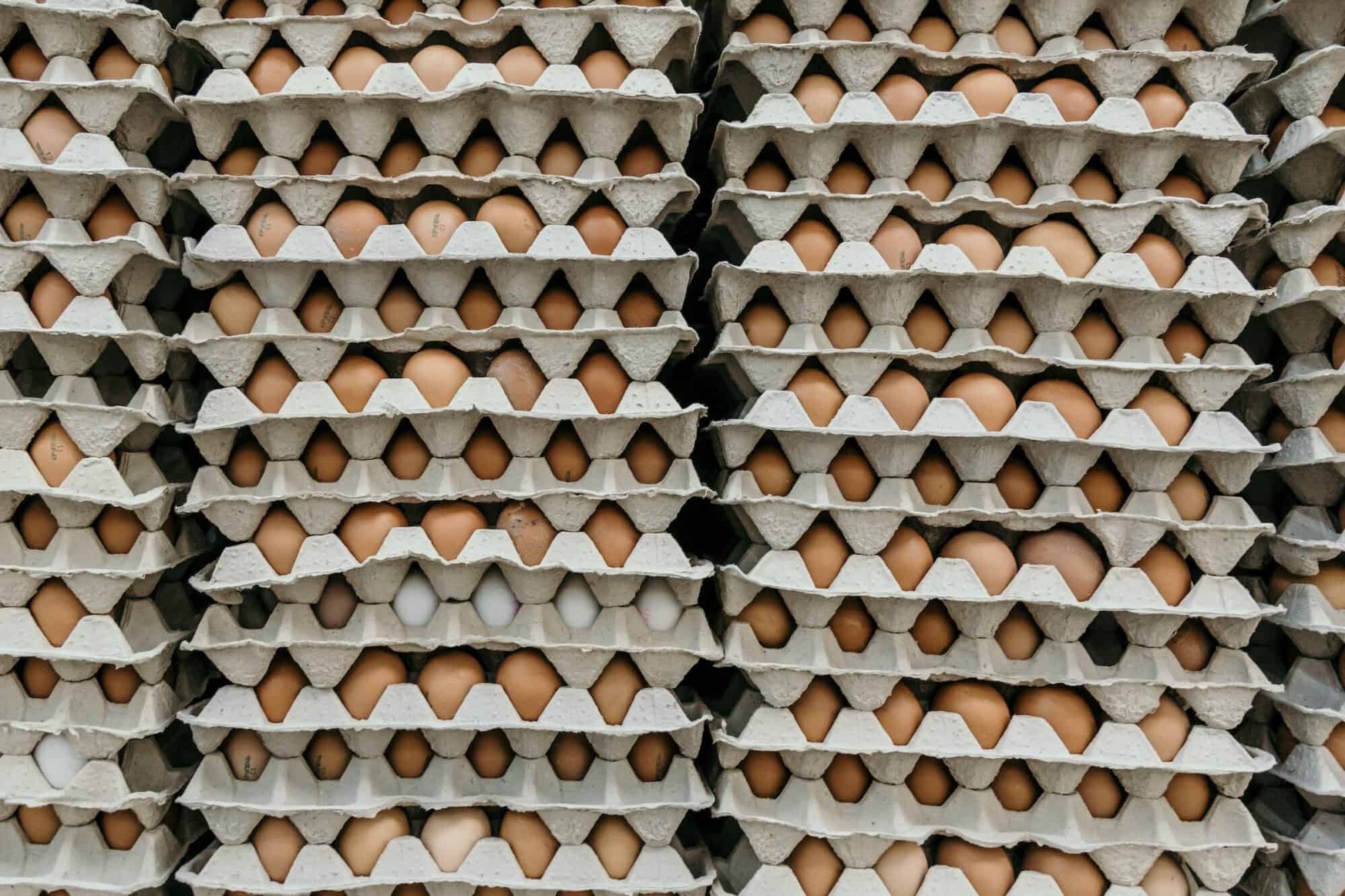 Stacks of brown eggs in cartons.