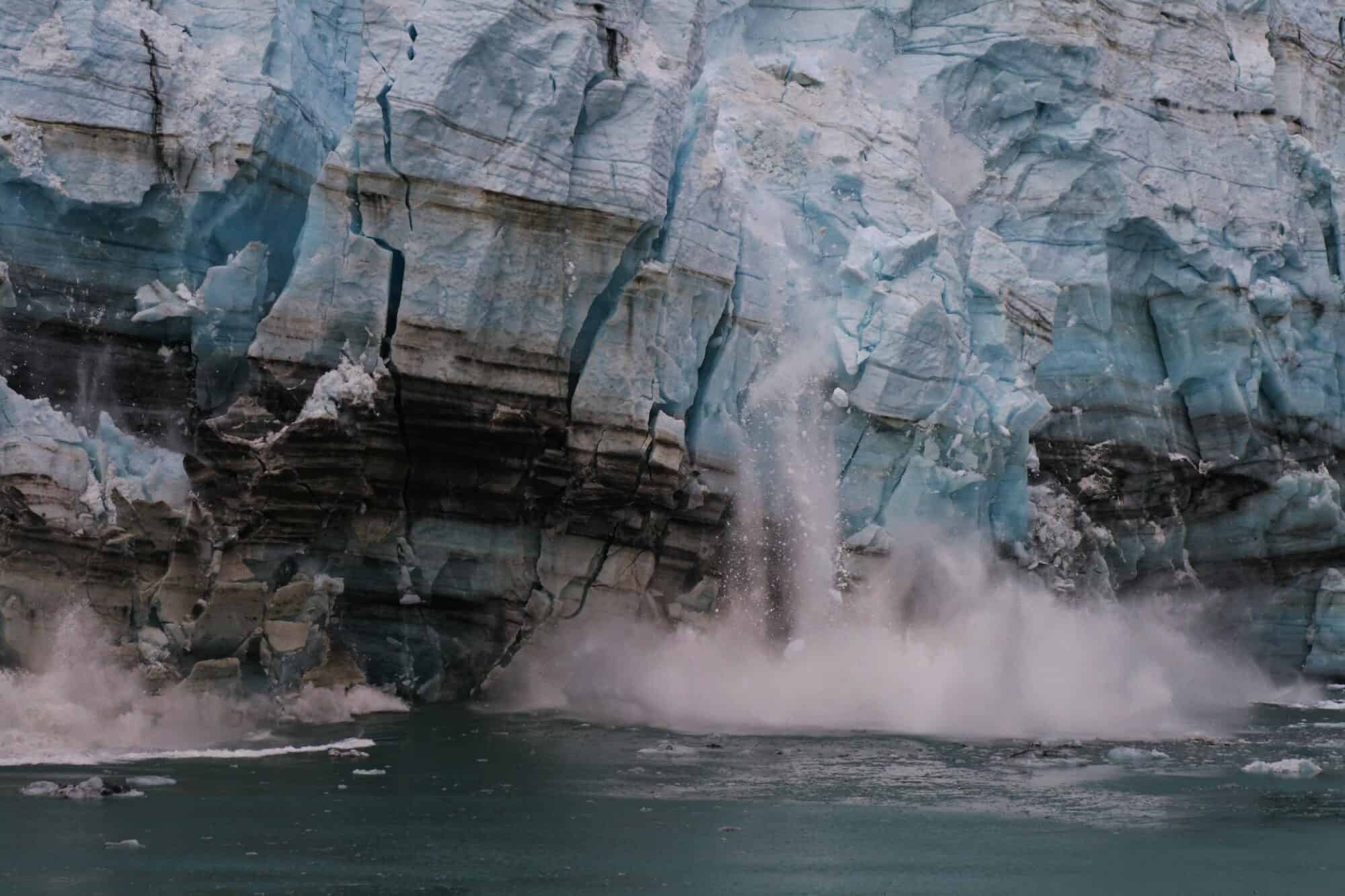 A melting glacier crashes into the ocean.
