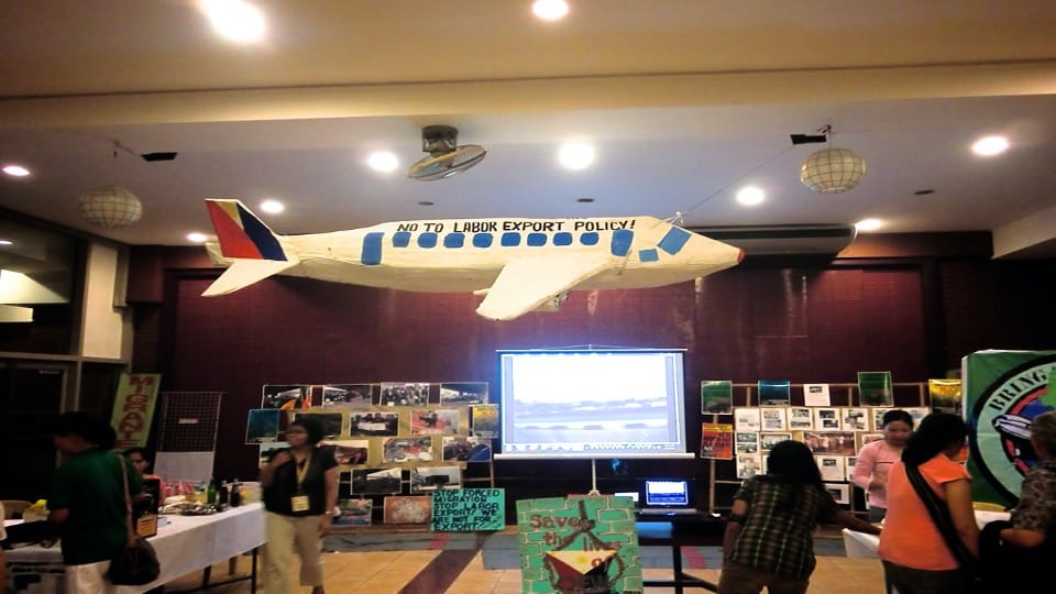 A paper mache "No to Labor Export" airplane hangs on the ceiling during the International Migrants Alliance meeting in July 2011 at the University of the Philippines, Diliman in Quezon City, Philippines.